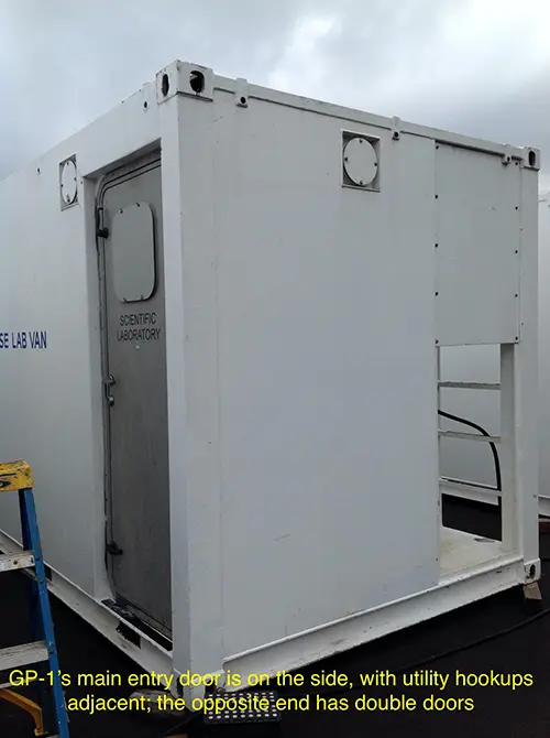 The white exterior of a portable lab van showing the entry door.
