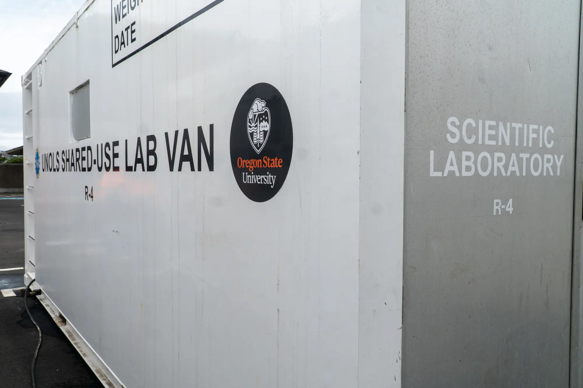 The white exterior of a portable lab van with an Oregon State University decal.