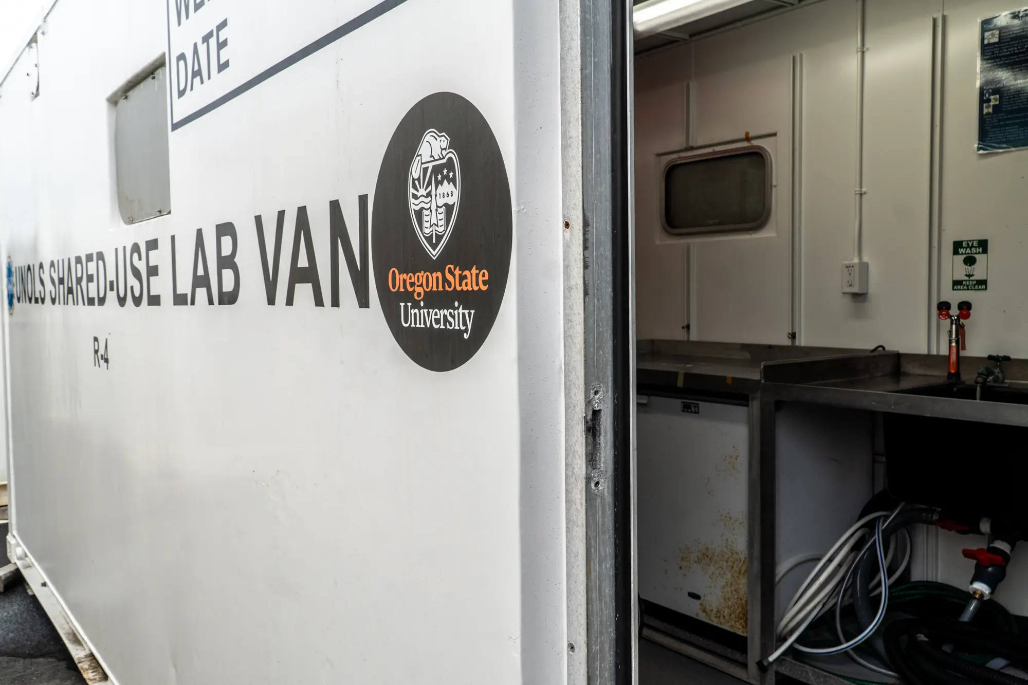 The white exterior of a portable lab van with an Oregon State University decal.