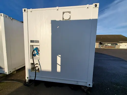 The white exterior of a lab van showing utility hookups. 