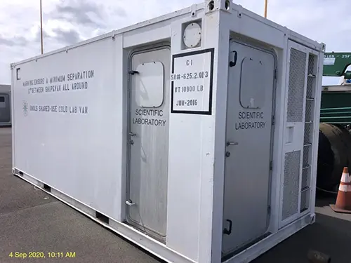 The white exterior of a lab van showing two adjacent silver doors.