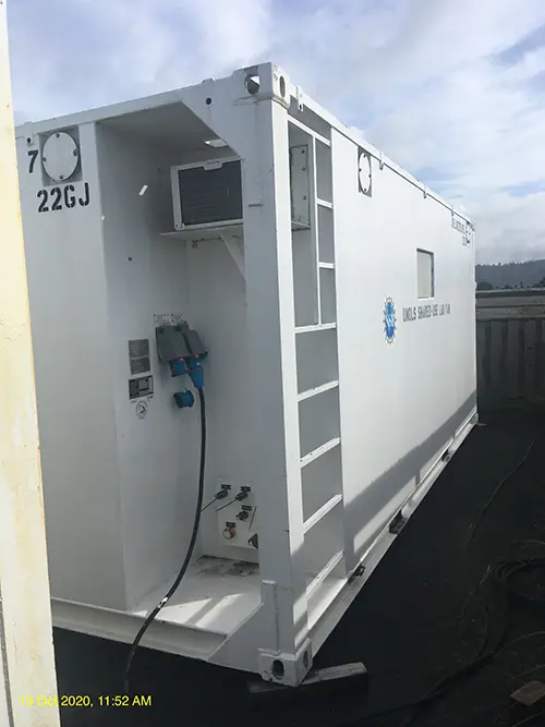 The white exterior of a lab van showing its utility hookups.