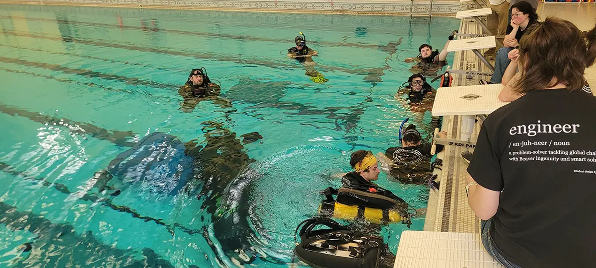 A swiming pool with people in scuba gear. 